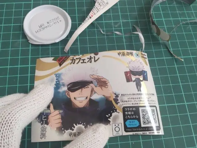 コラボ缶の空き缶のイラスト部分を切り取って伸ばしている写真