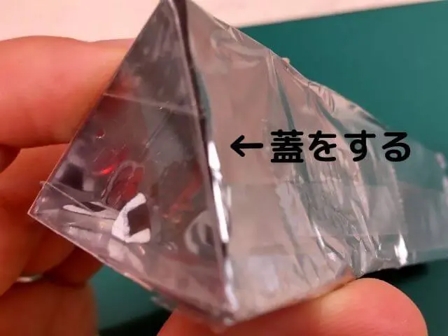 アルミホイルで包んだ三角形の筒の蓋をする写真