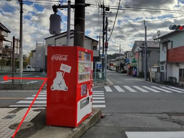 横断歩道を渡って左に曲がる矢印がついた交差点の写真