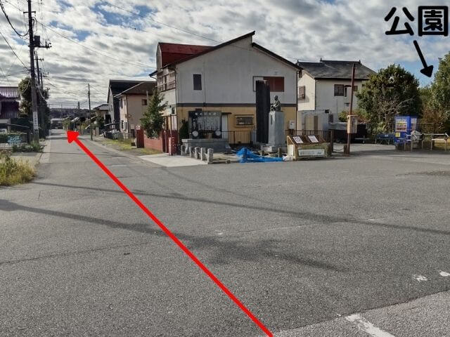 横田駅を背中にして正面をみた風景の写真に進む道の矢印が記されている写真
