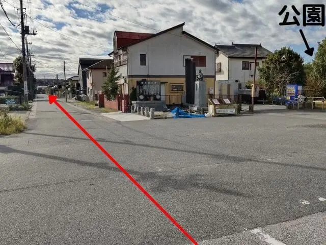 横田駅を背中にして正面をみた風景の写真に進む道の矢印が記されている写真