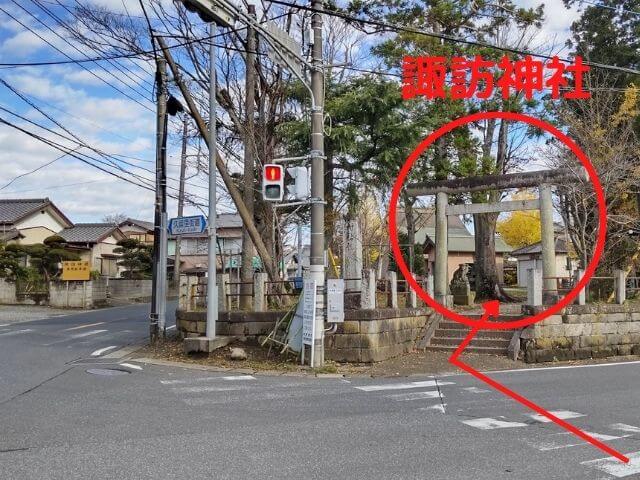 信号のある交差点で横断歩道を渡ればすぐ諏訪神社があるところの写真