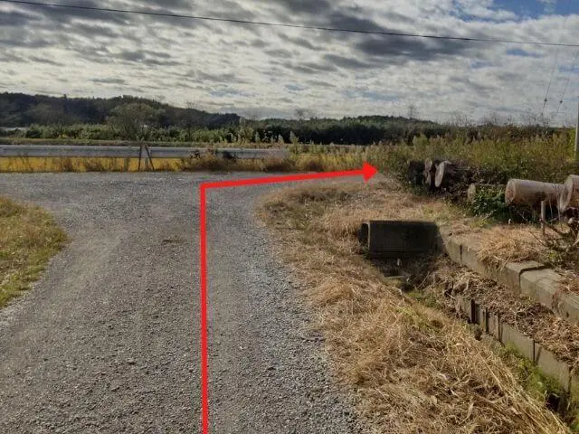 横田神社を背中にして原っぱを右に曲がる矢印のついた写真