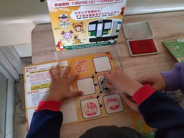 馬来田駅でスタンプをおしている写真