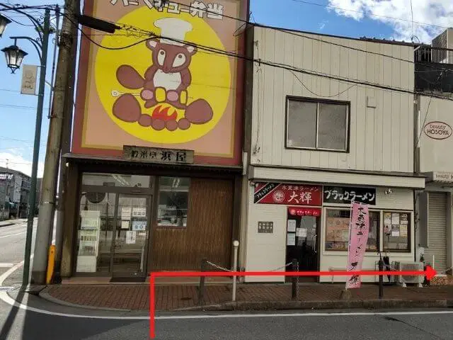 黄色い看板にコック帽をかぶったたぬきのイラストがある「浜屋」の写真