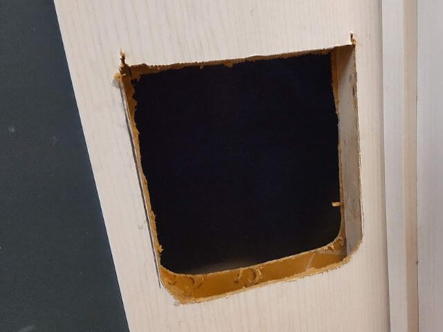 キャットドア取り付け位置のドアに穴が開き向こう側が見えるところの写真