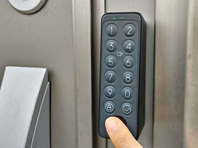 Switchbotスマートロックと指紋認証キーパッドタッチを使用して鍵のロックを指紋認証で解除しているところの写真